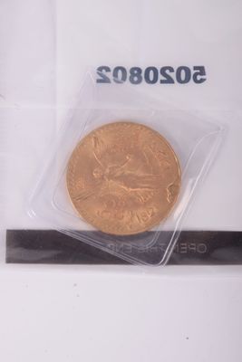 a gold coin in a plastic bag on a white surface