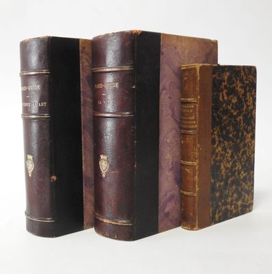 several old books are lined up in a row on a white surface