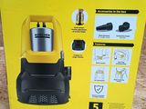 Le carton d'un aspirateur Karcher est ouvert et posé par terre.