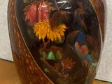 un vase sur lequel sont peints un oiseau et des fleurs