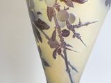 un vase avec un oiseau posé sur une table