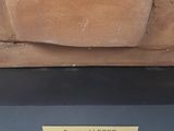 a statue of a man sitting on top of a wooden bench