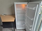 un réfrigérateur vide, la porte ouverte, à côté d'un bureau