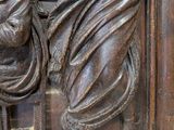 carvings of a man and a woman on a wooden panel