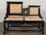 a black bench with two seats on it on a wooden floor