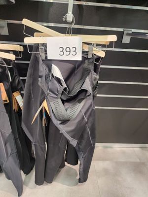 plusieurs parapluies suspendus à un porte-parapluies dans un magasin, avec leurs étiquettes de prix