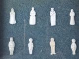 a lot of white figurines on display in a glass case