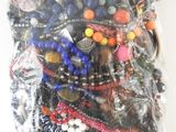 a bag of assorted beaded bracelets on a white surface