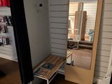 une pièce avec un miroir, un banc et une bibliothèque