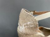 someone is holding a pair of shoes with a bow on them