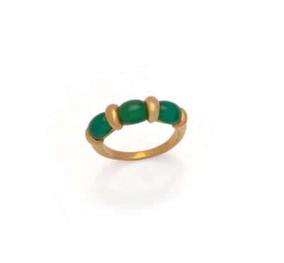 a close up of a gold ring with green stones on it