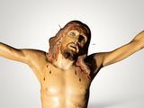 a statue of jesus on the cross with blood all over it