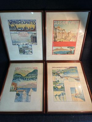 quatre affiches encadrées représentant différents pays sont exposées sur un fond noir