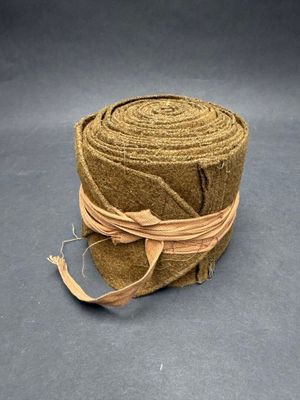 rope wrapped around a roll of brown paper on a gray surface
