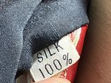 a close up of a person ' s hand holding a red and white tie