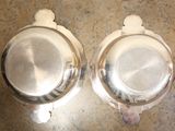 two silver dishes sitting on a counter top