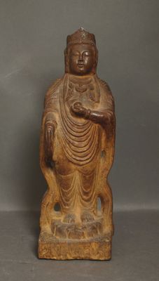 une vieille statue en bois représentant un Bouddha assis sur un rocher