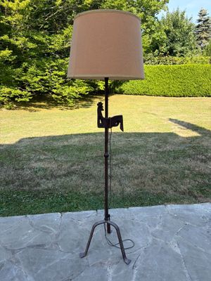une lampe posée sur un trépied dans le jardin