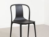 La chaise noire se trouve dans un coin de la pièce.