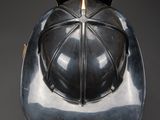 an old helmet with a metal cover on a black background