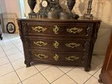 a dresser with a clock on top of it in a room