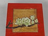 une petite boîte rouge décorée d'une peinture représentant des fleurs