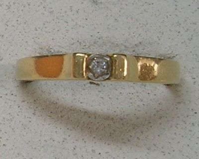 une photo d'une bague en or jaune sertie d'un diamant