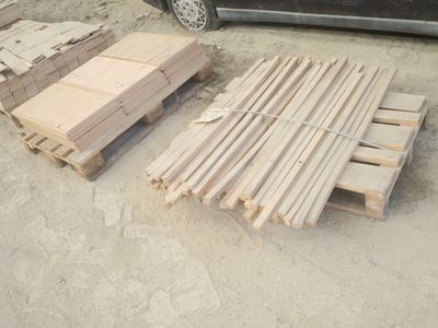 un tas de bois posé par terre à côté d'une voiture