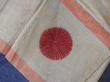 a close up of a piece of cloth with a red flower on it