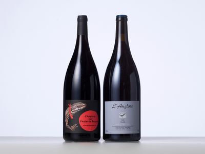 deux bouteilles de vin posées sur une table l'une à côté de l'autre