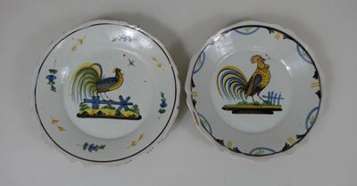 deux assiettes ornées de coqs, posées sur une table