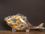 un poisson en verre posé sur une table en bois