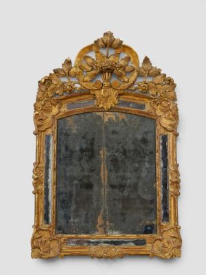 un miroir avec un cadre doré sur le mur