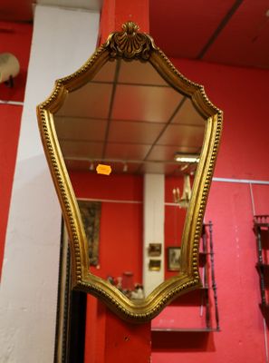 a mirror hanging on a red wall in a room