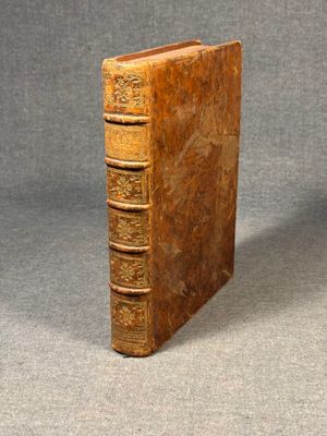 an old book sitting on top of a table on a gray surface