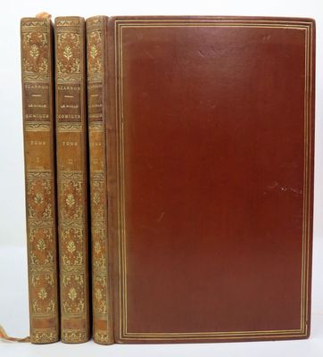 two old books sitting on top of each other on a white surface