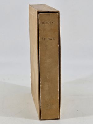 an old book sitting on top of a cardboard box on a white surface