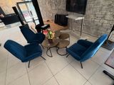 un salon avec des fauteuils bleus et une télévision à écran plat