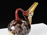 a brown and yellow vase with a bird on it