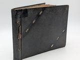 an old black leather book with a zipper on the front