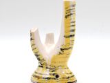 a yellow and white vase with a black and white design on it