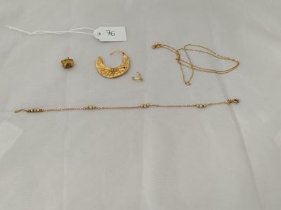a close up of a white sheet with gold jewelry on it