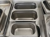 many metal pans lined up on a counter