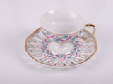 tea cup and saucer with floral decoration on saucer and saucer