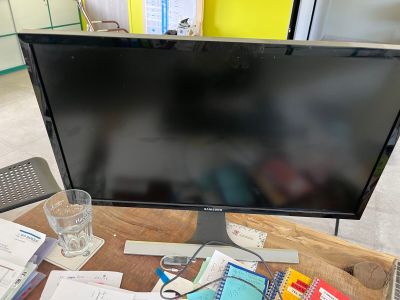 un écran d'ordinateur posé sur un bureau en bois