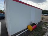 an image of a white and red building in a parking lot