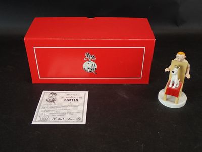 une petite figurine devant une boîte rouge