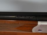 a close up of a rifle on a wooden table with a white background