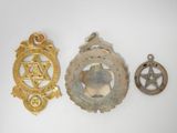 three medals and a star of david on a white surface