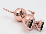 pair of rose gold plated metal bells on a white background
